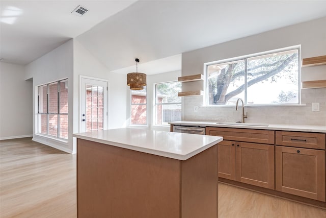 kitchen featuring open shelves, visible vents, light wood finished floors, and a sink