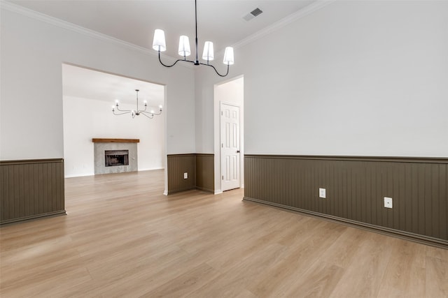 interior space featuring a notable chandelier, wainscoting, a fireplace, and visible vents