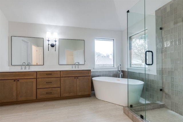 bathroom featuring a sink, a freestanding bath, double vanity, and a shower stall