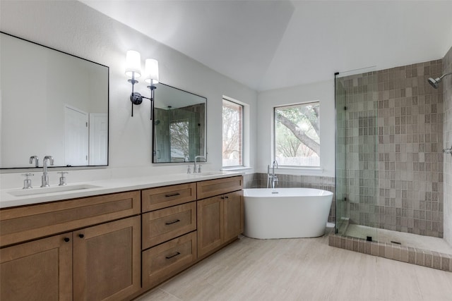 bathroom with double vanity, a stall shower, and a sink