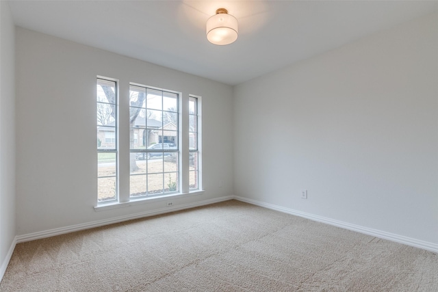 unfurnished room featuring baseboards and carpet