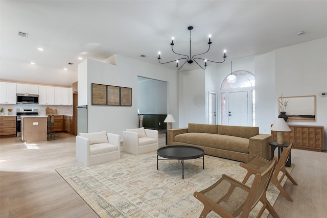 living area with recessed lighting, light wood-style floors, and visible vents