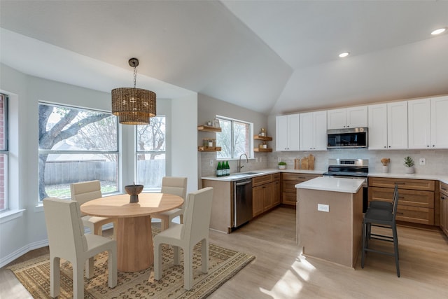 kitchen with open shelves, a sink, appliances with stainless steel finishes, light countertops, and decorative backsplash