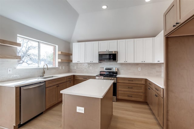 kitchen with open shelves, a sink, a center island, stainless steel appliances, and vaulted ceiling