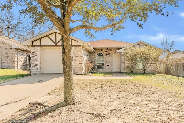 view of front facade featuring concrete driveway, an attached garage, fence, and brick siding