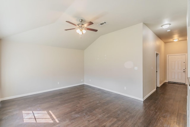 empty room with lofted ceiling, dark wood-style floors, visible vents, and baseboards