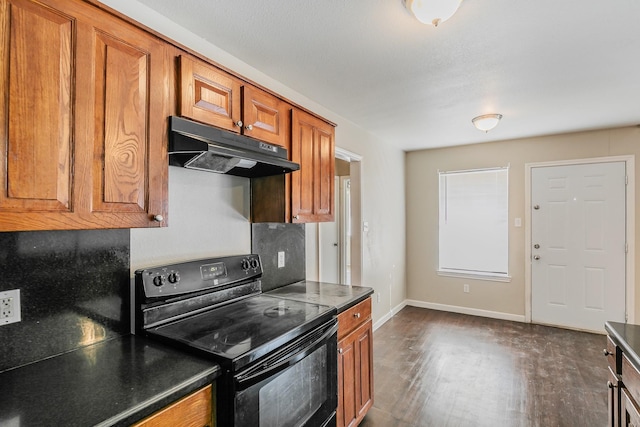 kitchen with baseboards, dark wood-style flooring, black range with electric stovetop, under cabinet range hood, and brown cabinets