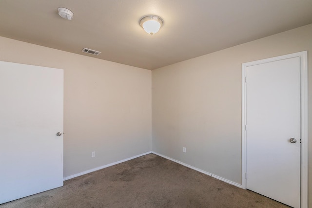 spare room with visible vents, carpet floors, and baseboards