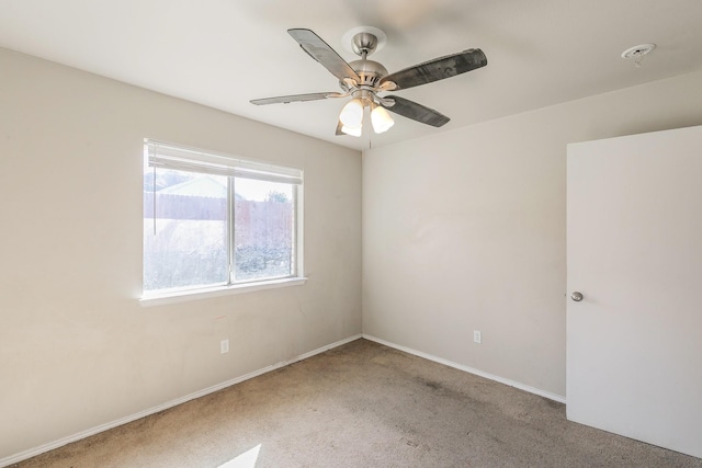 spare room with light carpet, baseboards, and ceiling fan