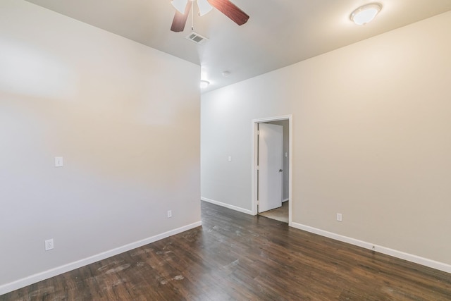 spare room featuring dark wood finished floors, visible vents, ceiling fan, and baseboards