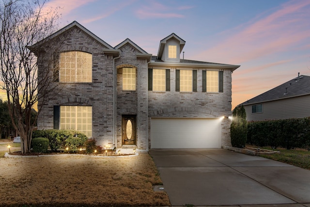 view of front of home with a garage, brick siding, and driveway