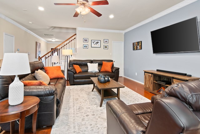 living room featuring visible vents, wood finished floors, ornamental molding, and stairs