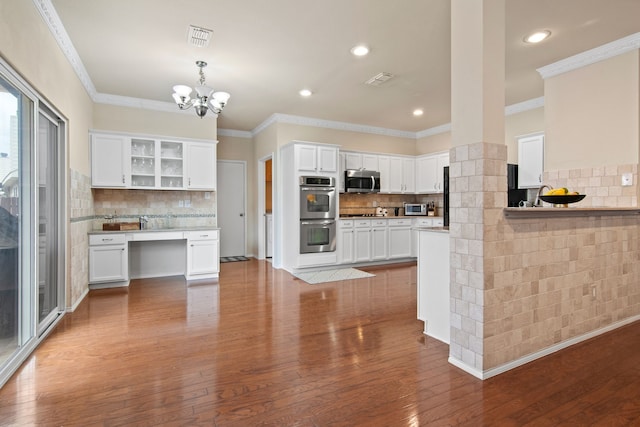 kitchen with visible vents, dark wood finished floors, decorative backsplash, stainless steel appliances, and white cabinetry