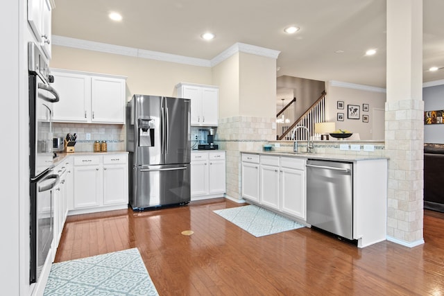 kitchen featuring stainless steel appliances, dark wood finished floors, and crown molding