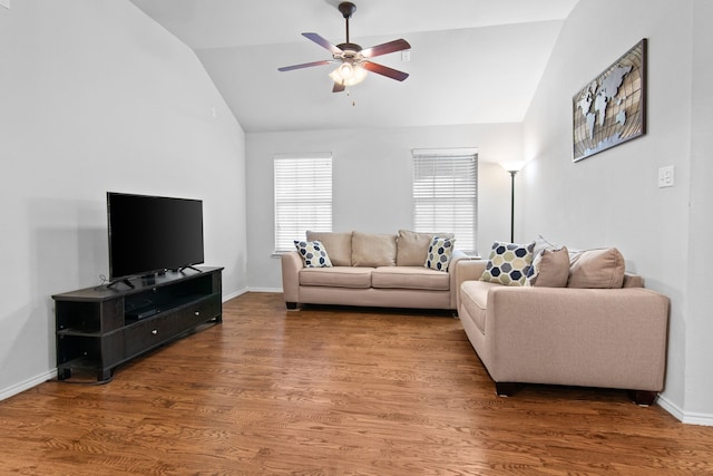 living area with a ceiling fan, vaulted ceiling, wood finished floors, and baseboards