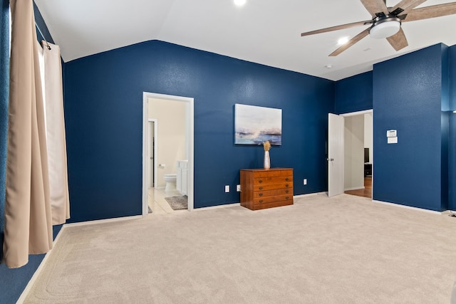 carpeted bedroom featuring lofted ceiling, ensuite bath, and a ceiling fan