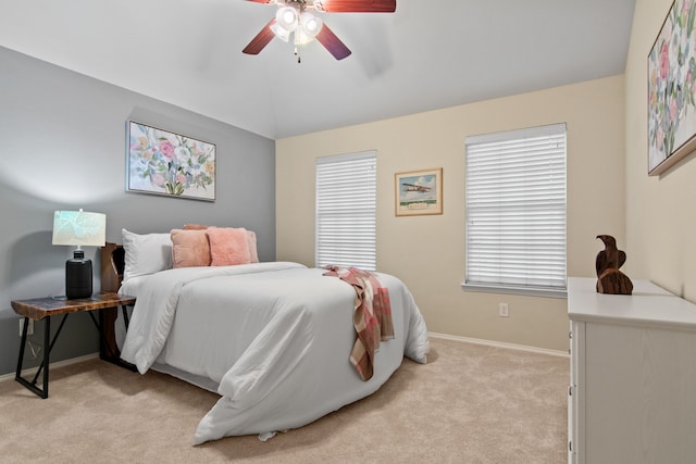 bedroom with baseboards, light carpet, lofted ceiling, and a ceiling fan