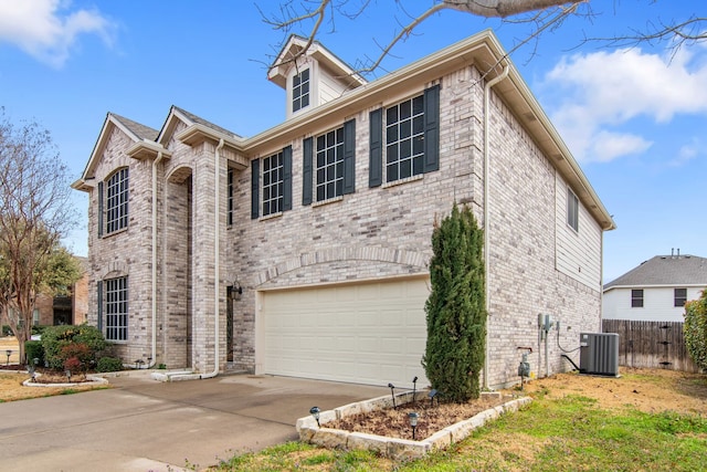 view of front of house featuring fence, cooling unit, concrete driveway, an attached garage, and brick siding