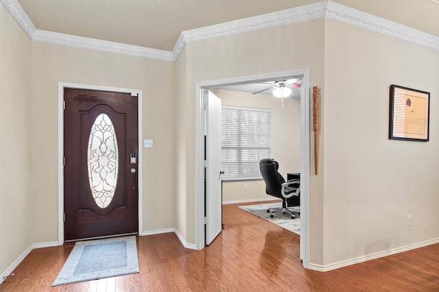 foyer entrance featuring baseboards, wood finished floors, and ornamental molding