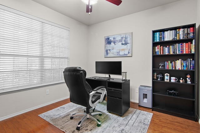 office featuring a ceiling fan, baseboards, and wood finished floors