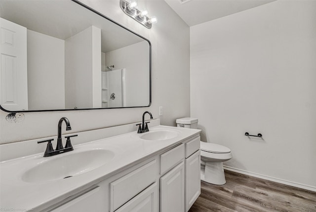 full bathroom featuring a shower, toilet, wood finished floors, and a sink