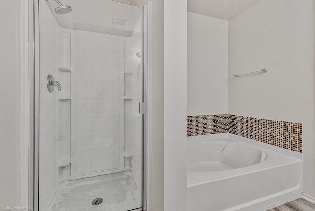 full bath featuring a garden tub, wood finished floors, and a stall shower