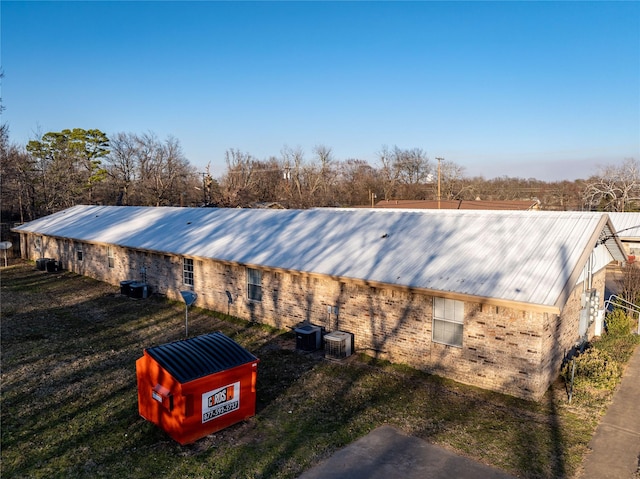 exterior space with metal roof and central AC unit