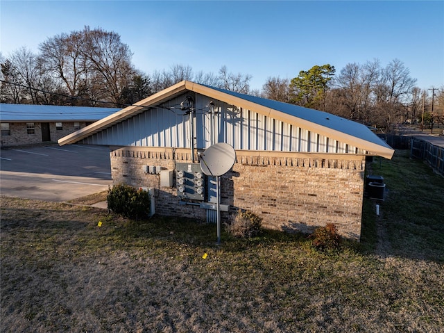 view of side of home featuring brick siding and uncovered parking