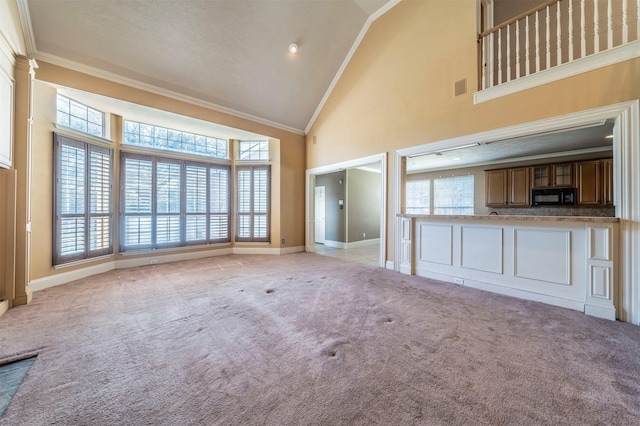 unfurnished living room featuring carpet flooring, plenty of natural light, and ornamental molding