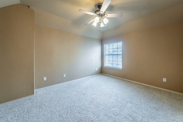 carpeted spare room with baseboards, ceiling fan, and vaulted ceiling