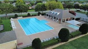 pool with a patio, an outdoor structure, and fence