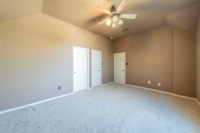 unfurnished bedroom featuring visible vents, light carpet, baseboards, ceiling fan, and vaulted ceiling