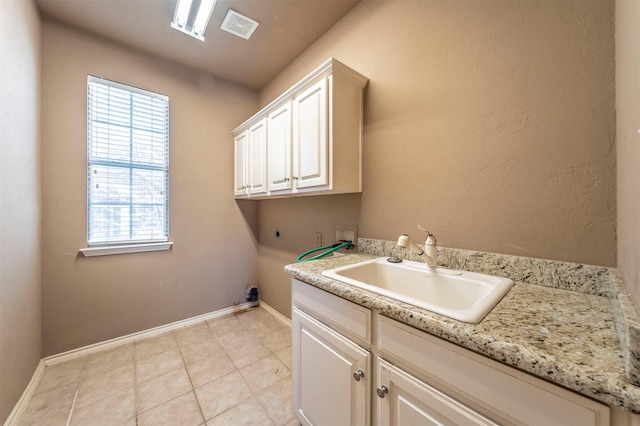 laundry room featuring hookup for a washing machine, baseboards, visible vents, cabinet space, and a sink