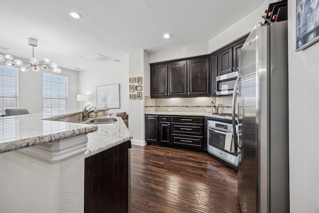 7917 Parkwood Blvd, Plano, TX 75024 - kitchen with appliances with stainless steel finishes, a sink, dark wood-style floors, light stone counters, and tasteful backsplash