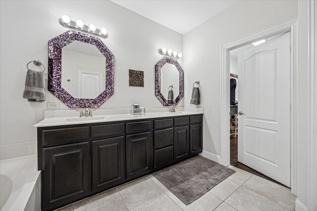 7917 Parkwood Blvd, Plano, TX 75024 - bathroom with double vanity, a garden tub, a walk in closet, tile patterned flooring, and baseboards