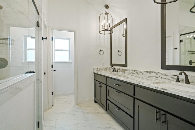 bathroom with double vanity, a stall shower, marble finish floor, and a sink