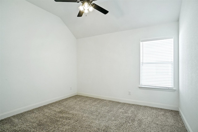 spare room featuring baseboards, a ceiling fan, carpet flooring, and vaulted ceiling