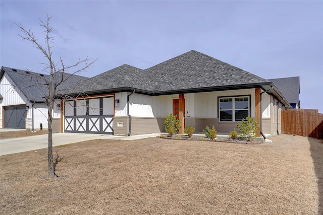 view of front of property with a garage, fence, driveway, and a shingled roof