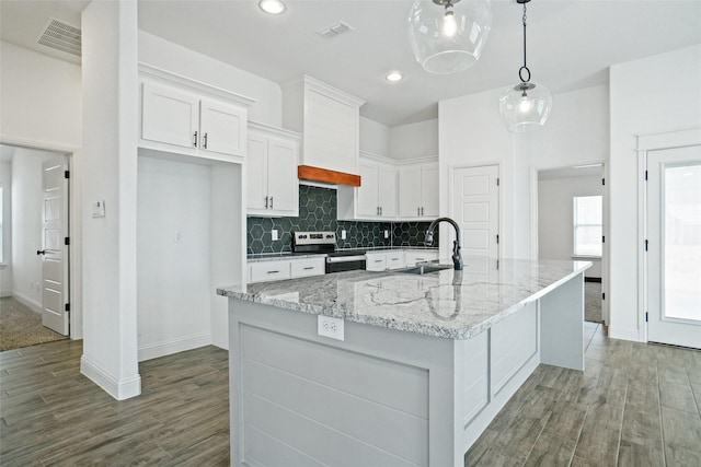 kitchen featuring visible vents, a sink, white cabinetry, stainless steel electric range, and decorative backsplash