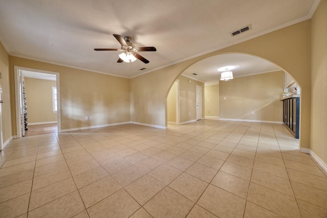 spare room featuring a ceiling fan, light tile patterned flooring, visible vents, and arched walkways