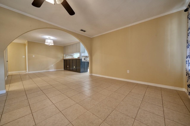 unfurnished room featuring arched walkways, visible vents, light tile patterned floors, and ornamental molding