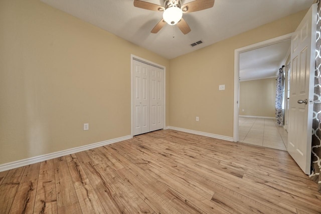 unfurnished bedroom with visible vents, baseboards, a closet, and light wood finished floors