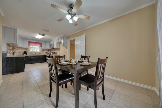 dining room with light tile patterned floors, visible vents, baseboards, and crown molding