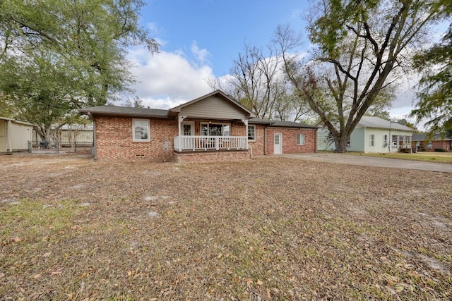 ranch-style home with crawl space, brick siding, and covered porch