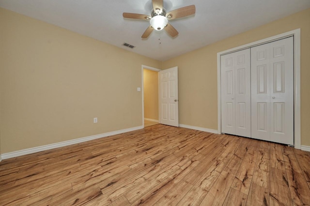 unfurnished bedroom featuring light wood-style flooring, baseboards, visible vents, and a closet