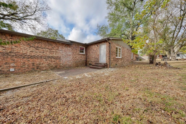 rear view of house featuring brick siding, crawl space, a patio area, and entry steps