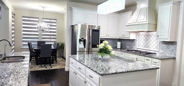 kitchen with dark wood finished floors, custom exhaust hood, a sink, white cabinets, and appliances with stainless steel finishes