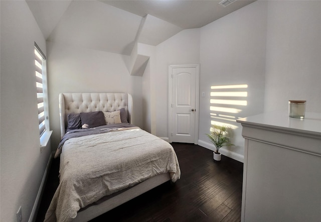 bedroom with dark wood finished floors, vaulted ceiling, visible vents, and baseboards