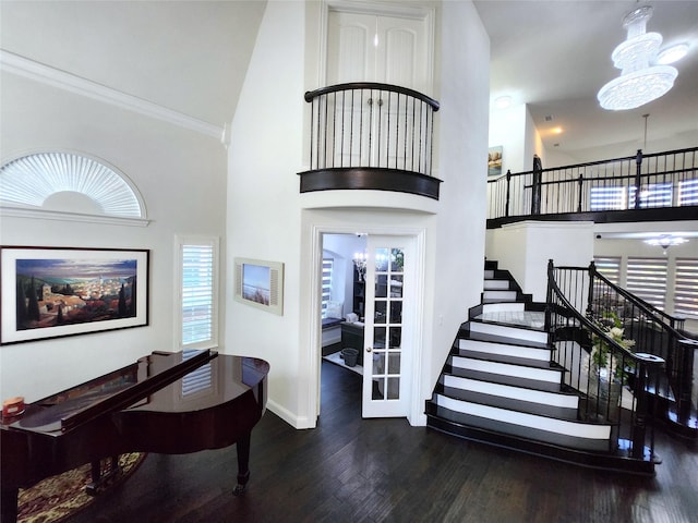 entrance foyer featuring a chandelier, stairway, high vaulted ceiling, and wood finished floors