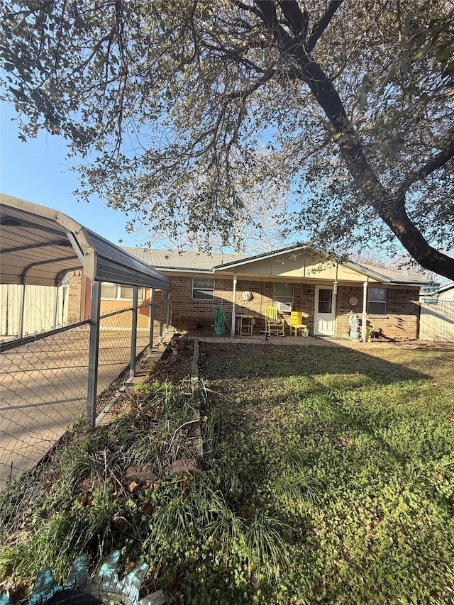 rear view of house with a yard and fence